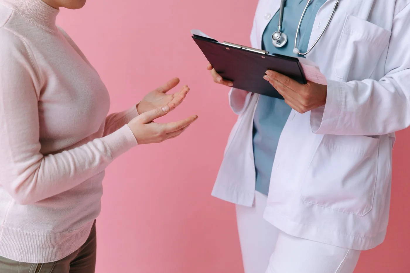 A patient discussing questions with a clinician holding a clipboard